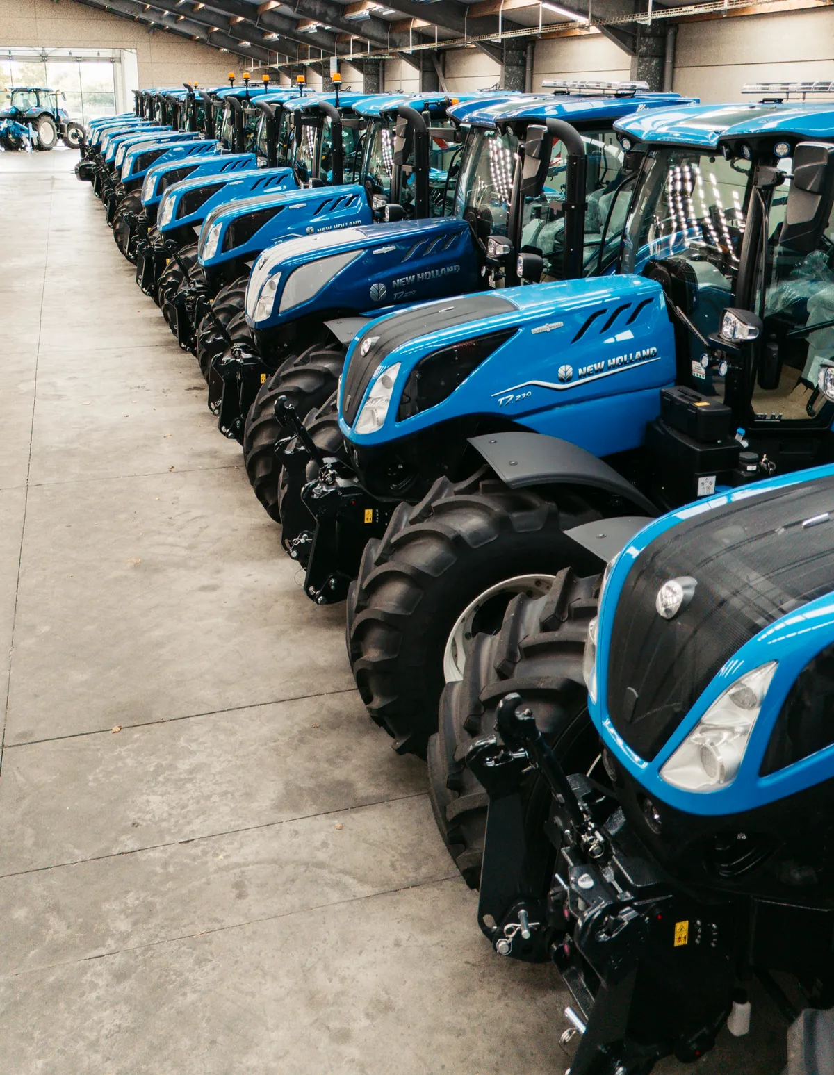 Een rij New Holland tractoren in de Westtrac showroom